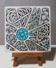 an intricately designed tile on a wooden stand