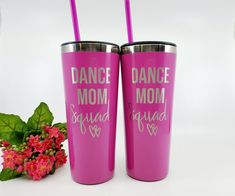 two pink tumblers with the words dance mom and squad on them next to flowers