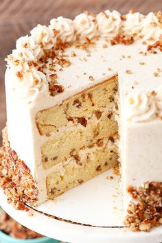 a cake with white frosting and pecans on top