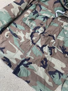 "Make this camo US Army jacket yours. 100% Cotton Features durable zipper closure, visible in images Hood tucked into collar Sleeve can be tucked into velcro closure Length: 28\" Bust: 44\" Waist: 44\" Shoulder: 18\" Sleeve: 22\"" Us Army Jacket, Military Style Camouflage Hooded Jacket For Outdoors, Military Camouflage Windbreaker For Winter, Winter Military Camouflage Hooded Jacket, Military Camouflage Outerwear With Buttons, Camouflage Military Hooded Long Sleeve Jacket, Army Camo, Handmade Backpacks, Jacket With Hood