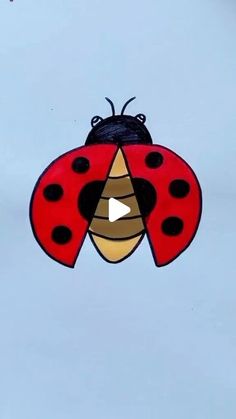 a red and black ladybug kite flying in the sky