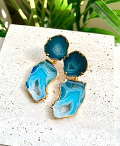 "Add a pop of color to your outfit with the stunning Janet geode earrings! These bright blue earrings feature an intricate stone pattern and crystal quartz center that wonderfully illustrates nature's beauty. 2 1/2\" Long 24k Gold Edged Lightweight" Blue Agate Geodes With Natural Stones, Blue Agate Geodes, Handmade Blue Geodes As Gifts, Handmade Blue Geodes For Gifts, Handmade Blue Geodes As A Gift, Handmade Blue Geodes For Gift, Blue Agate Earrings As A Gift, Geode Earrings, Agate Geode