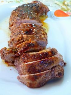 two pieces of meat on a plate with mustard and seasoning next to the meat