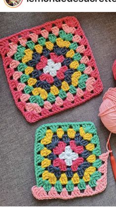 two crocheted squares with yarn on the floor