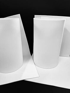 three white vases sitting on top of each other