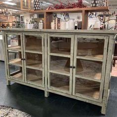 a large display cabinet with glass doors and shelves on the top, in a store