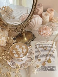 a table topped with lots of different types of jewelry next to a cup of coffee