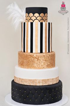 a three tiered cake with black, white and gold stripes