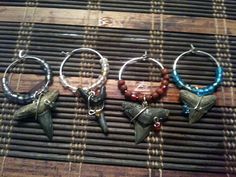 four different types of wine charms sitting on top of a wooden table next to a bamboo mat