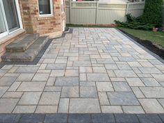 a brick patio in front of a house