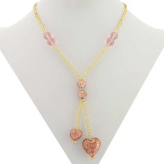 A statement of sophistication, elegance, and style, this Murano Heart Necklace is an instant hit with women of all ages and tastes. The handcrafted Murano Glass Tie necklace features two beautiful tender hearts in shades of creamy rose and pink sparkling with infused pieces of copper and suspended from strings of exquisite gold seed beads. The matching ball-shaped Murano Glass beads along with Swarovski crystals in the middle make a stylish accent. This necklace is a great expression of your lov Rose Gold Heart Beads Necklace, Elegant Pink Heart Necklace With Heart Beads, Pink Double Heart Elegant Jewelry, Elegant Pink Double Heart Jewelry, Elegant Adjustable Pink Gold Necklace, Feminine Rose Gold Necklaces For Valentine's Day, Elegant Pink Gold Adjustable Necklace, Feminine Rose Gold Necklace For Valentine's Day, Elegant Adjustable Double Heart Necklace