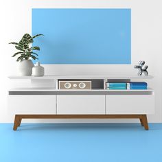 an entertainment center with blue and white paint on the walls, two planters sitting on top of it