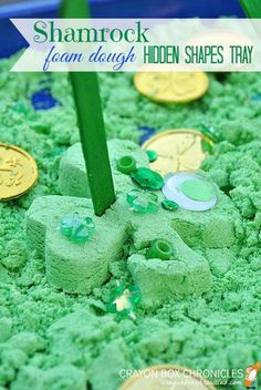 a close up of a cake with green frosting and shamrocks on it, surrounded by coins