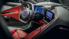 the interior of a car with red leather seats and dashboards, including an electronic display