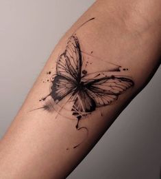 a black and white butterfly tattoo on the arm