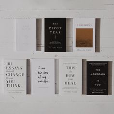 five books are lined up against a white wall