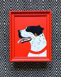 a painting of a black and white dog on an orange frame with diamond pattern background