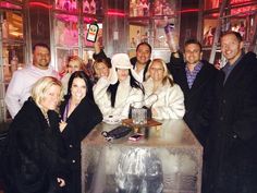 a group of people posing for a photo in front of a table with ice on it