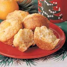 some muffins are on a red plate next to lemons and a christmas tree