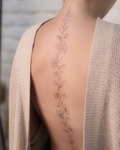 the back of a woman's body with flowers on her upper and lower back