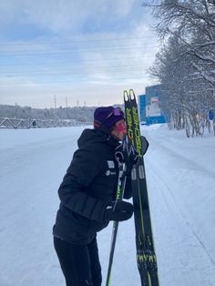 a man holding his skis in the snow