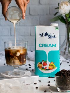 milk being poured into a glass filled with ice cream