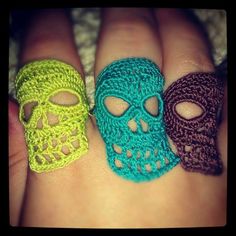 three crocheted sugar skulls sitting next to each other on someone's foot