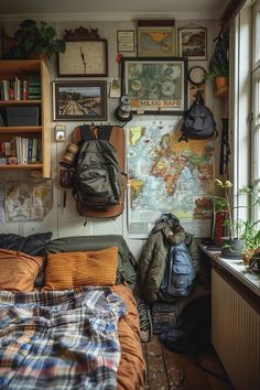 a bedroom with a map on the wall and backpacks hanging up against the wall