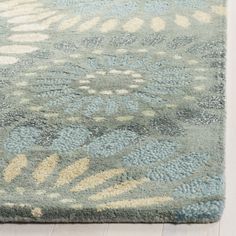 a blue and beige rug with flowers on it