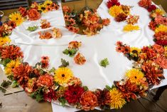 an arrangement of flowers arranged in the shape of a heart on top of a table