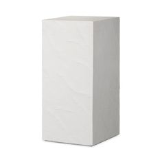 a tall white vase sitting on top of a table