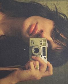 a woman holding a camera taking a selfie with her eyes closed and nose close to the camera