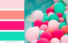 there are many balloons in the water and one is pink, green, and blue