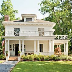 a large white house sitting on top of a lush green field