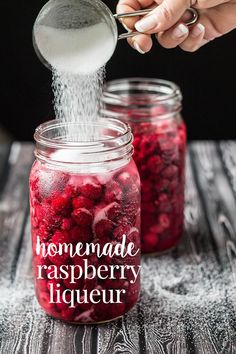 someone pouring raspberry liquer into a jar with the words homemade raspberry liquer in it