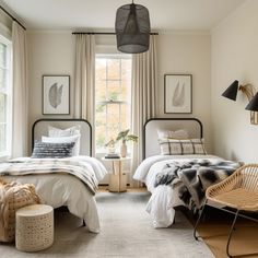 two beds in a bedroom with white walls