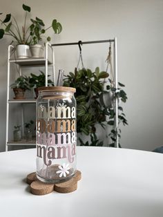 a glass jar sitting on top of a white table next to two cork coasters