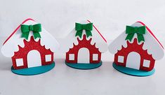 three red and white paper houses with green bows