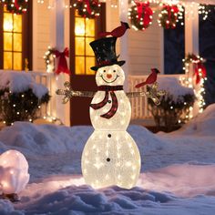 a lighted snowman in front of a house