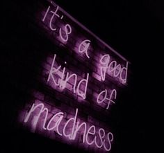 a neon sign that says it's a good kind of madness on the side of a building