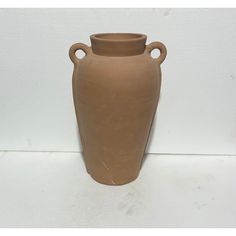 a large brown vase sitting on top of a white floor