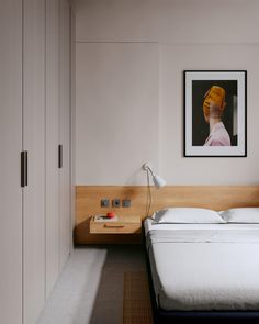 a bedroom with a bed, nightstand and pictures on the wall