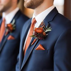 three men in suits with boutonnieres on their lapels, one wearing an orange bow tie