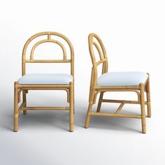 two chairs made out of bamboo with blue cushions on the seat and backrests