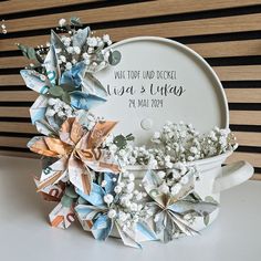 an origami flower arrangement in a tea cup