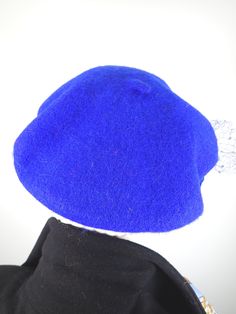 This women's warm and cozy gorgeous one of a kind royal blue French Beret Tam is a classic piece that never goes out of style. It's made of 100% wool that has been felted, creating a warm winter hat that keeps the cold air at bay. The color is a gorgeous, deep royal blue color. It is embellished with a handmade rosette made from hand dyed silk ribbon, vintage velvet leaves, vintage netting and vintage rhinestone buttons. One of a kind, unique and beautiful! ++++++++++++++++++++++++++++++++++++++ Brimmed Blue Mini Hats For Winter, Blue Curved Brim Mini Hat For Winter, Blue Mini Hats With Curved Brim For Winter, Fitted Blue Cloche Hat For Winter, Blue Winter Mini Hat With Curved Brim, Blue Mini Hats For Winter, Fitted Blue Felt Hat For Winter, Classic Beret With Curved Brim, Fitted Blue Flat Cap