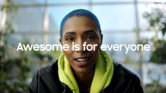 a woman with blue hair wearing a black jacket and yellow scarf around her neck that says, awesome is for everyone