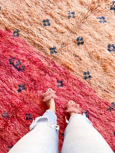 a person standing on top of a rug with their feet propped up in the middle