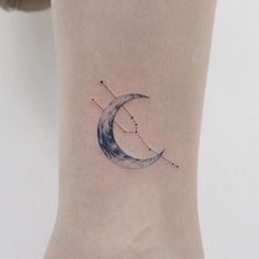 a woman's ankle with a tattoo on it that has a crescent and stars in the sky