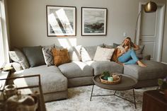 a woman sitting on top of a couch in a living room